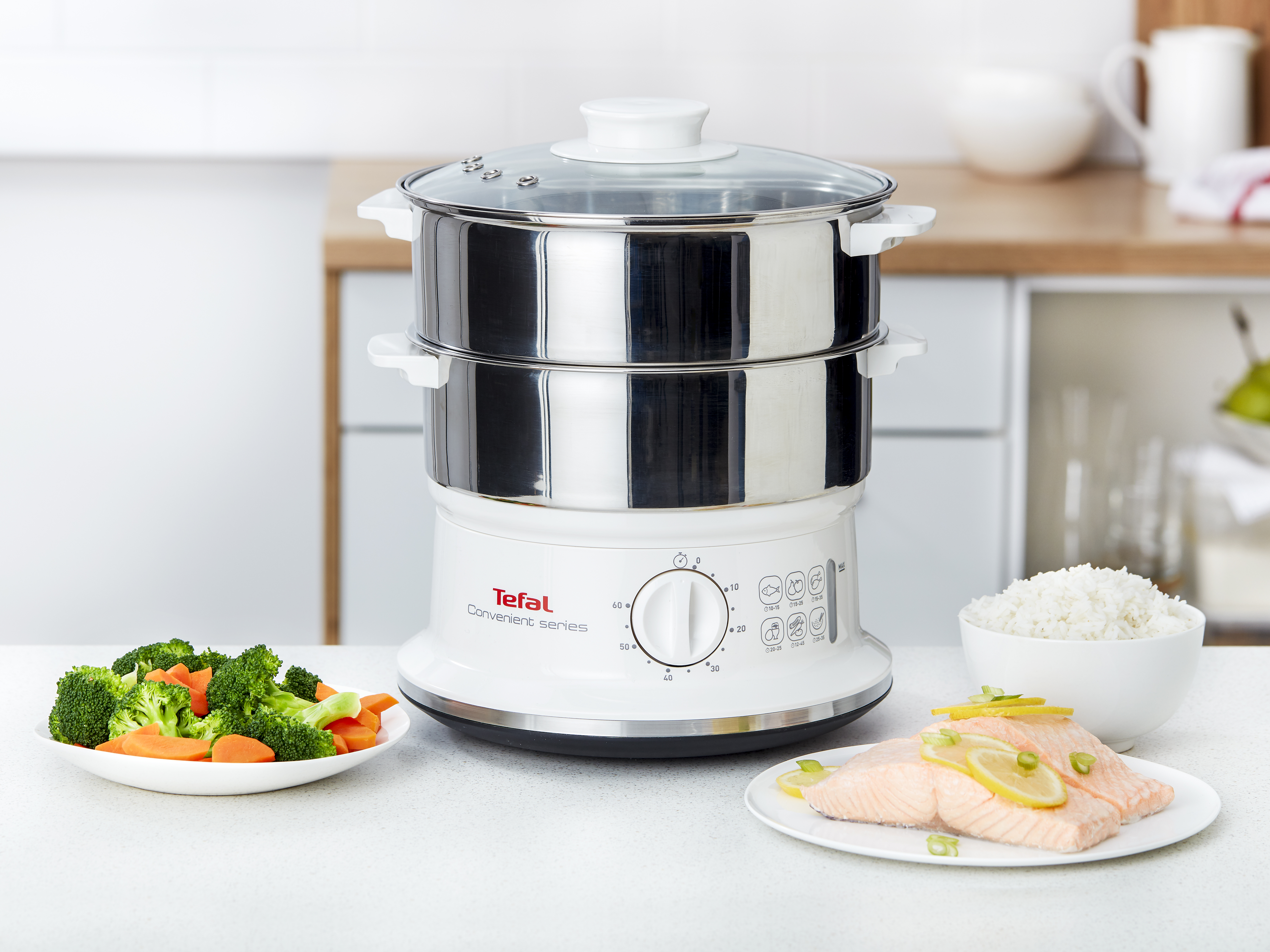 Tefal gőzölő zöldségekkel és lazaccal fehér felületen. Fehér háttér.