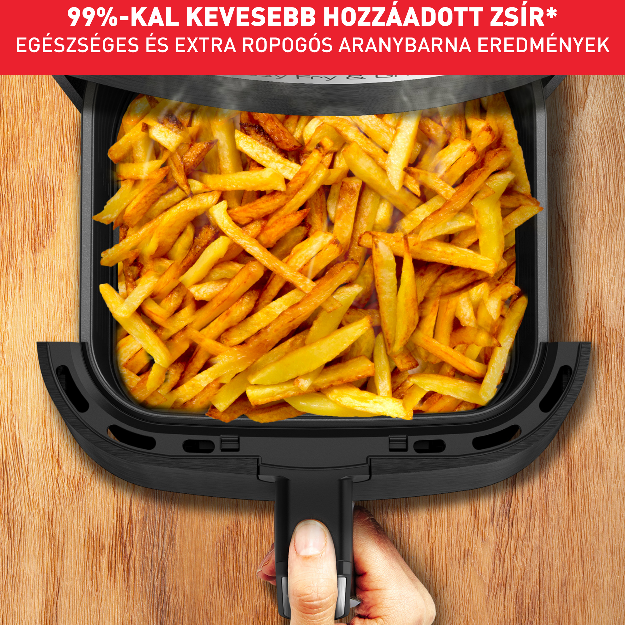 Forrólevegős sütő sült krumplival, kéz a fogantyún. Fa háttér.