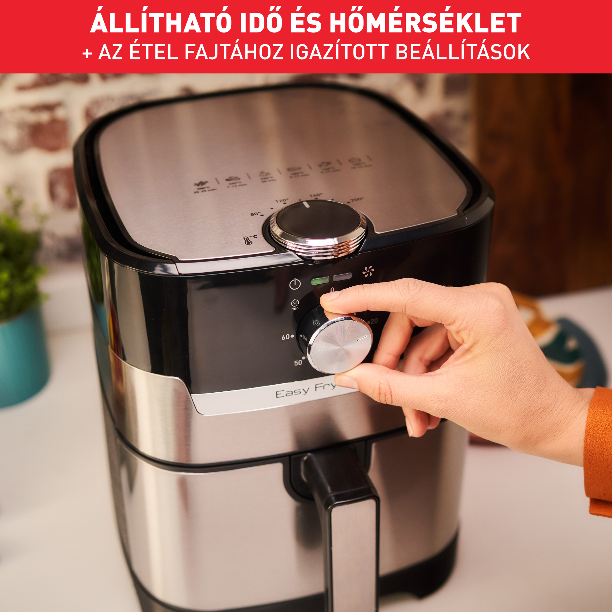 Levegősütő állítható idő- és hőmérséklet-beállításokkal. A kéz tekeri a gombot. Fekete és ezüst.