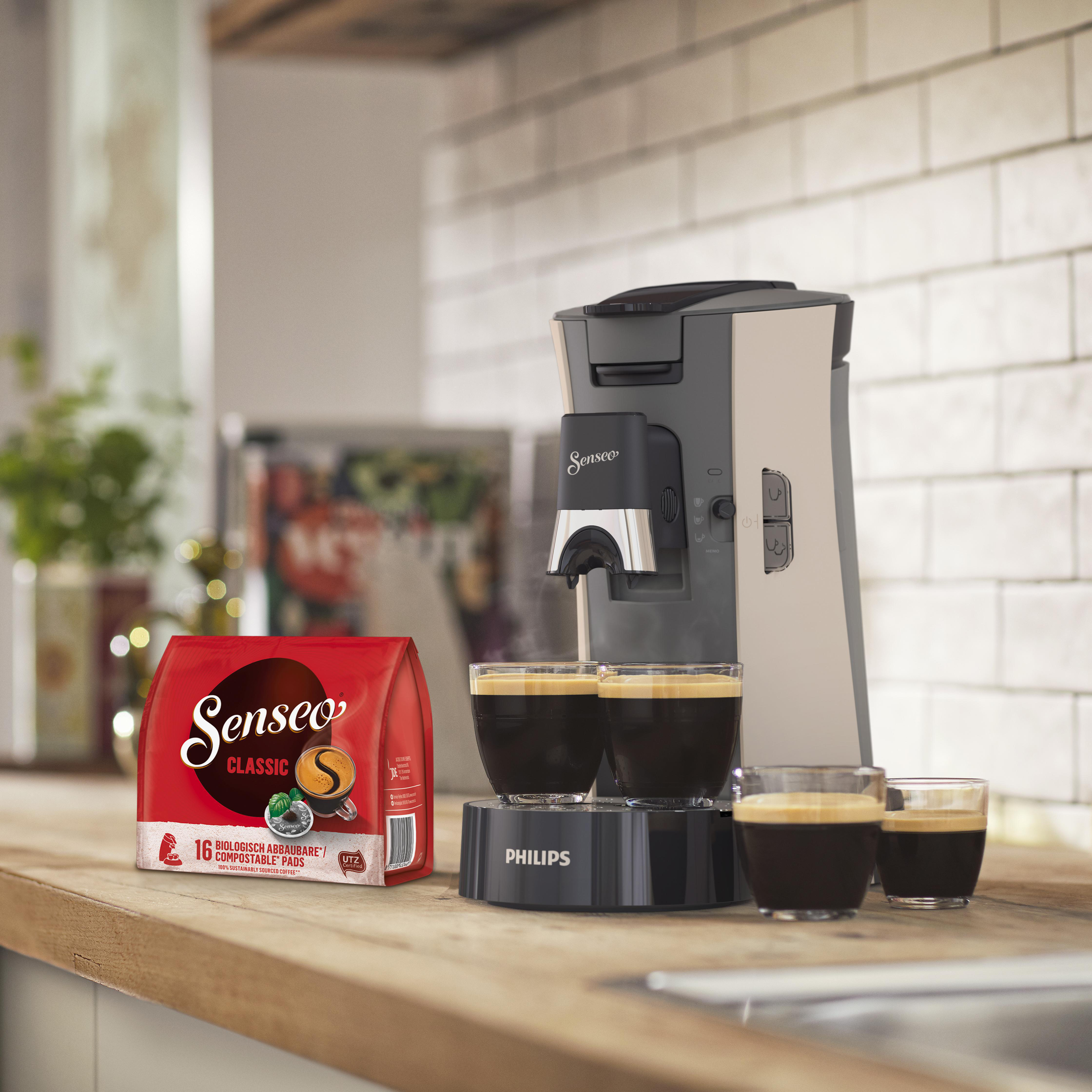 Kaffeemaschine, die Kaffee in zwei Gläser brüht. Roter Kaffeebeutel ist sichtbar.