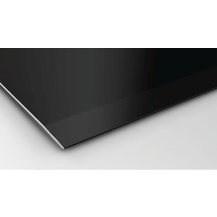 Primer plano de una superficie negra brillante, posiblemente una encimera o un aparato similar.