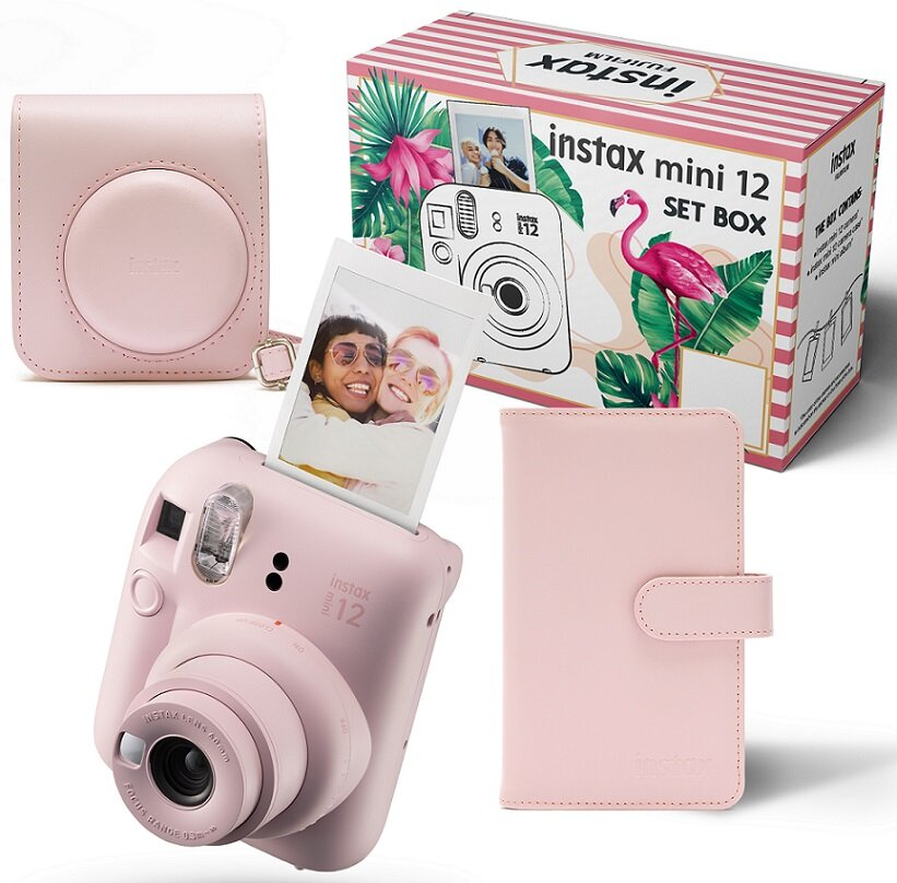 Różowy aparat Instax, etui i pudełko z zdjęciami, flamingiem i tropikalnymi liśćmi.