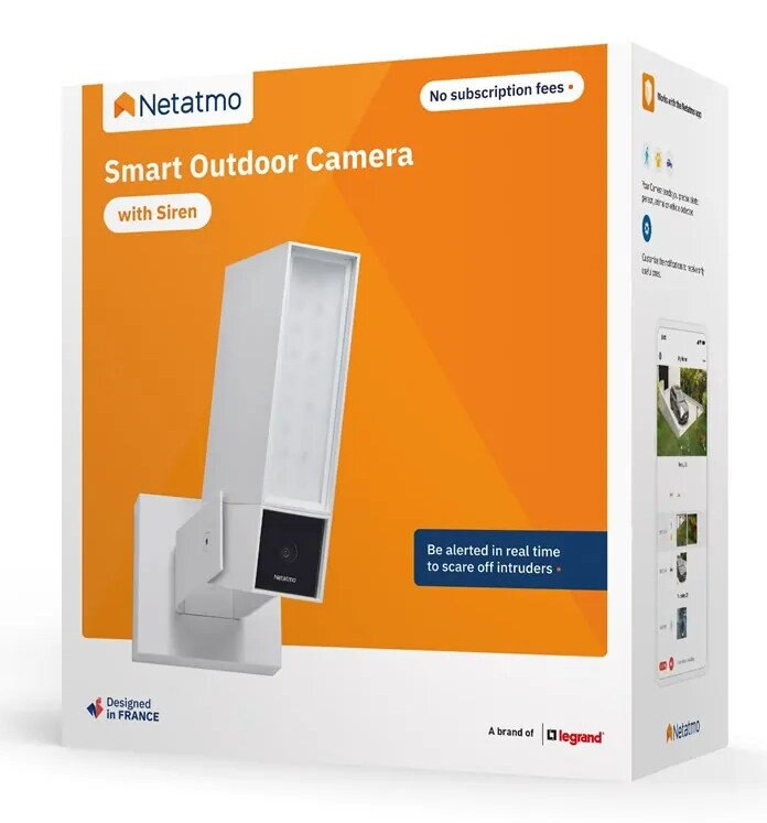 Pudełko Netatmo Smart Outdoor Camera. Biała kamera, pomarańczowe pudełko, tekst i cechy produktu są widoczne.