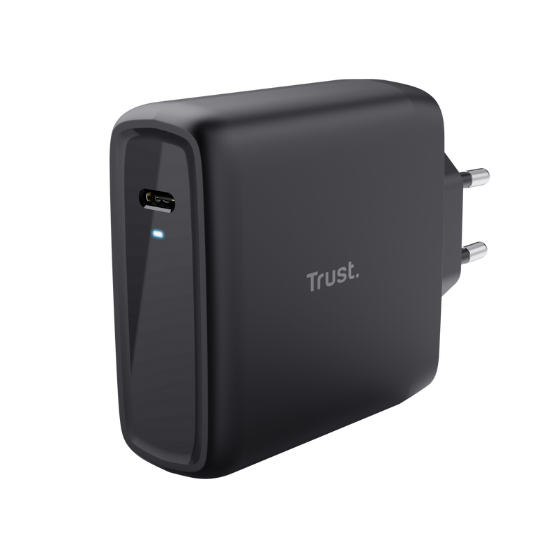 Fekete Trust töltő USB-C porttal és két dugóval a konnektorhoz fekete háttéren.