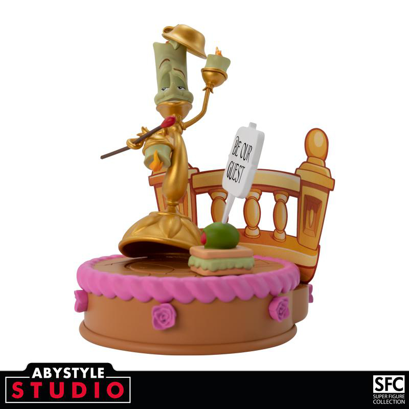 Eine Lumiere-Figur aus Die Schöne und das Biest auf einem Kuchen mit einem Schild.