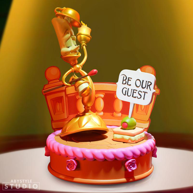 Lumiere aus Die Schöne und das Biest Statue. Goldene Kerzenständerfigur auf einer Bühne mit 'Be Our Guest'-Schild.