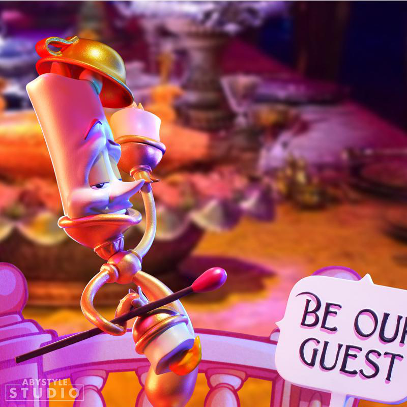 Lumiere aus Die Schöne und das Biest hält eine Fackel. Text: 'Be Our Guest'.
