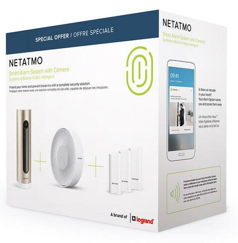 Pudełko systemu alarmowego Netatmo. Pokazuje elementy: kamerę, syrenę i czujniki drzwi. Ekran telefonu.