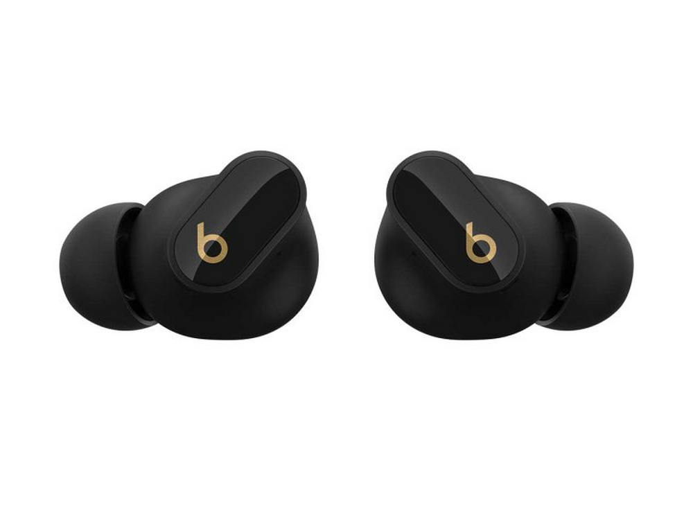 Auriculares Beats negros. Logotipo 'b' dorado en cada auricular. Fondo blanco. Toma en ángulo.