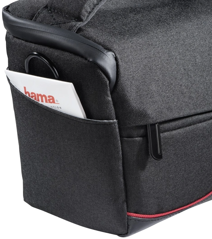 Close-up of a black camera bag with a pocket holding a white Hama card.
