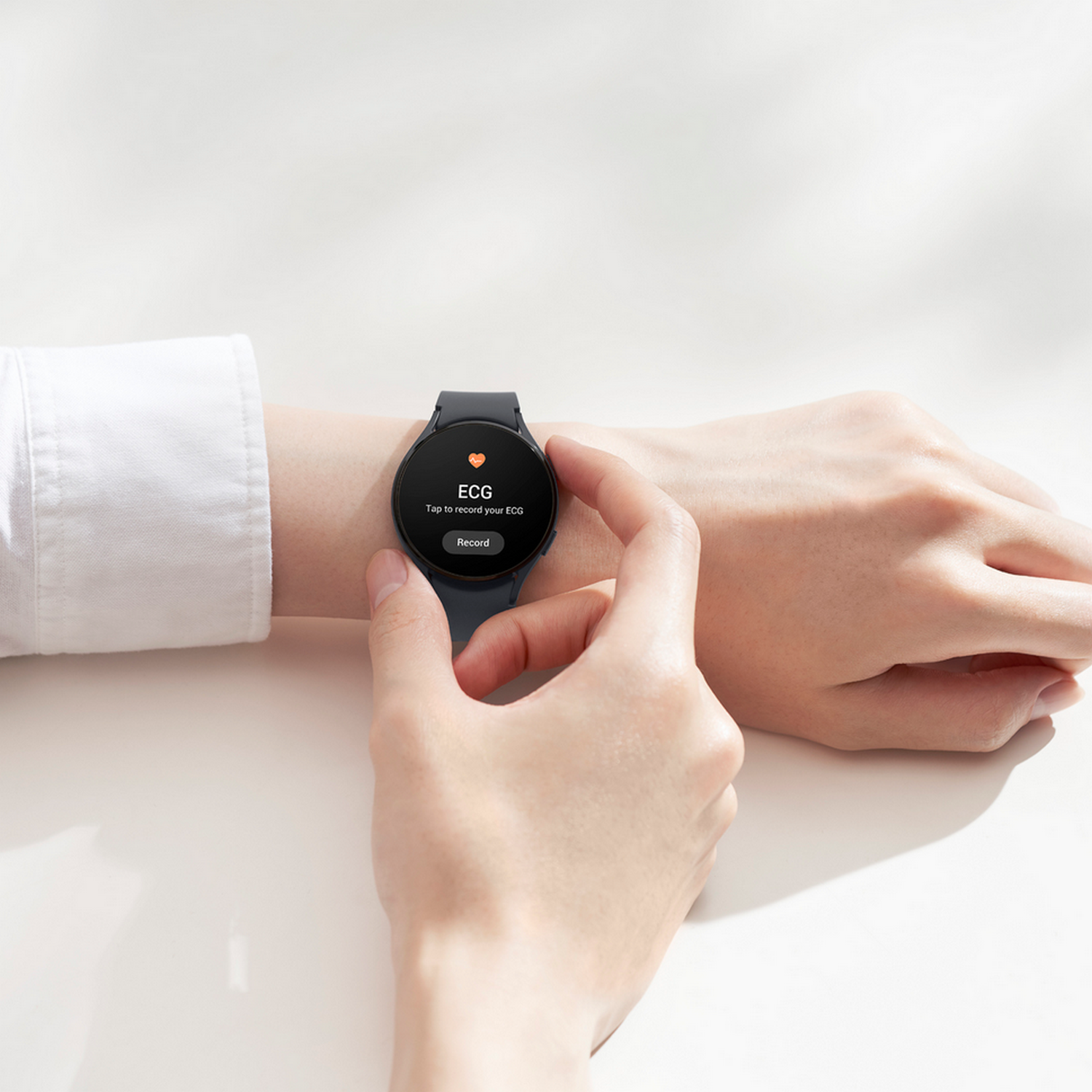 Een persoon die een horloge draagt en op het scherm tikt om een ECG op te nemen.