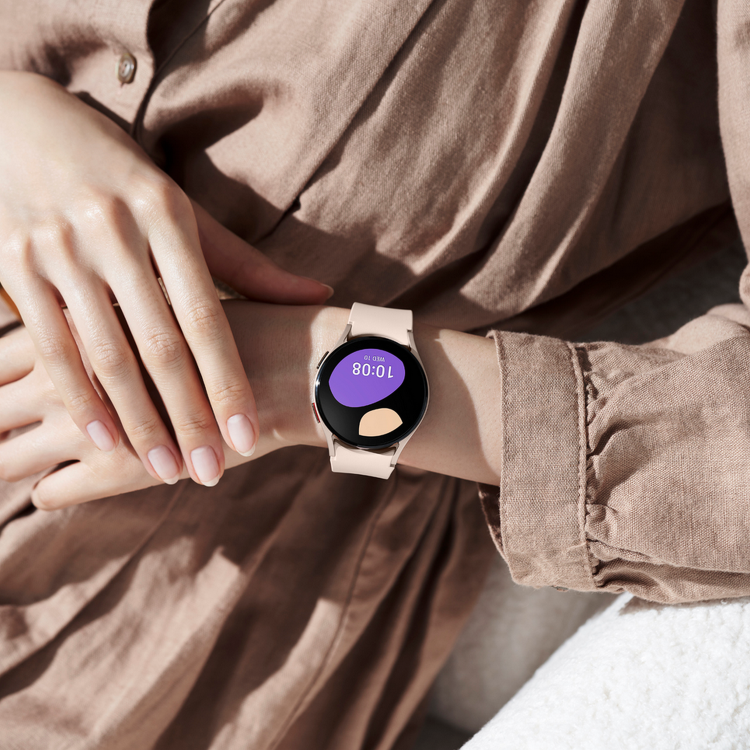 Pols met een smartwatch die de datum en tijd weergeeft. Het horloge heeft een roze bandje.