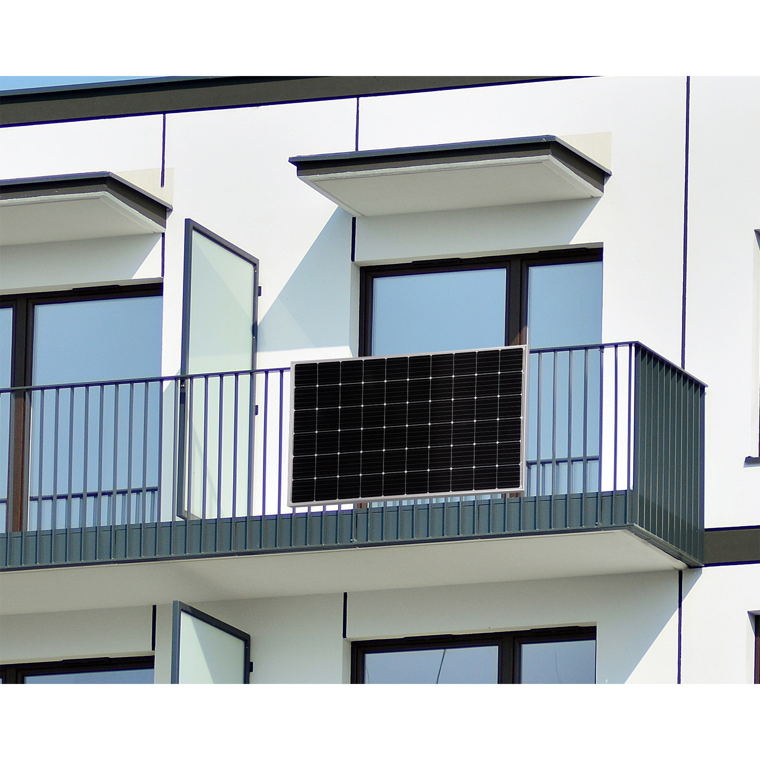 Pannello solare nero su un balcone, edificio bianco sullo sfondo.