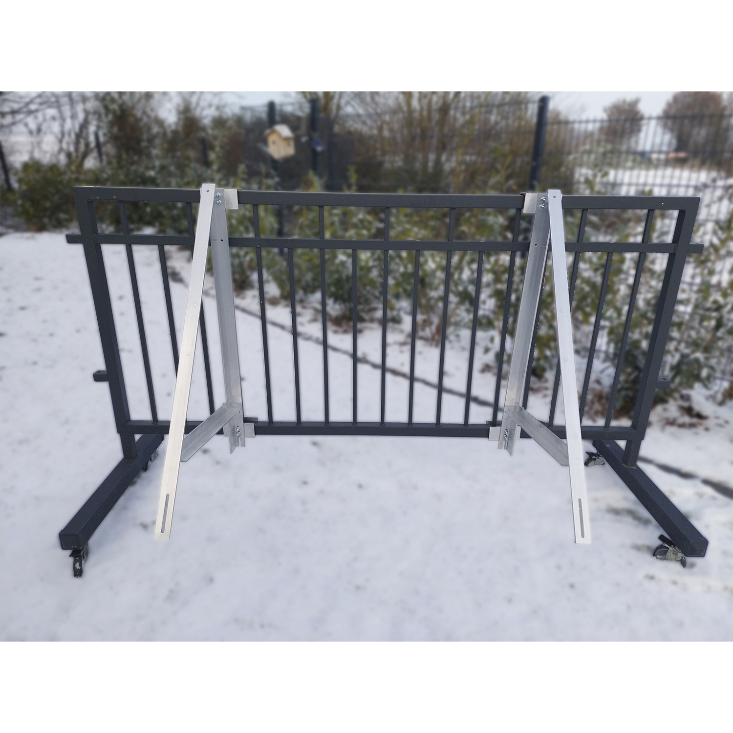 Recinzione metallica con supporto e neve. Un cancello metallico con strutture di supporto e sfondo innevato.