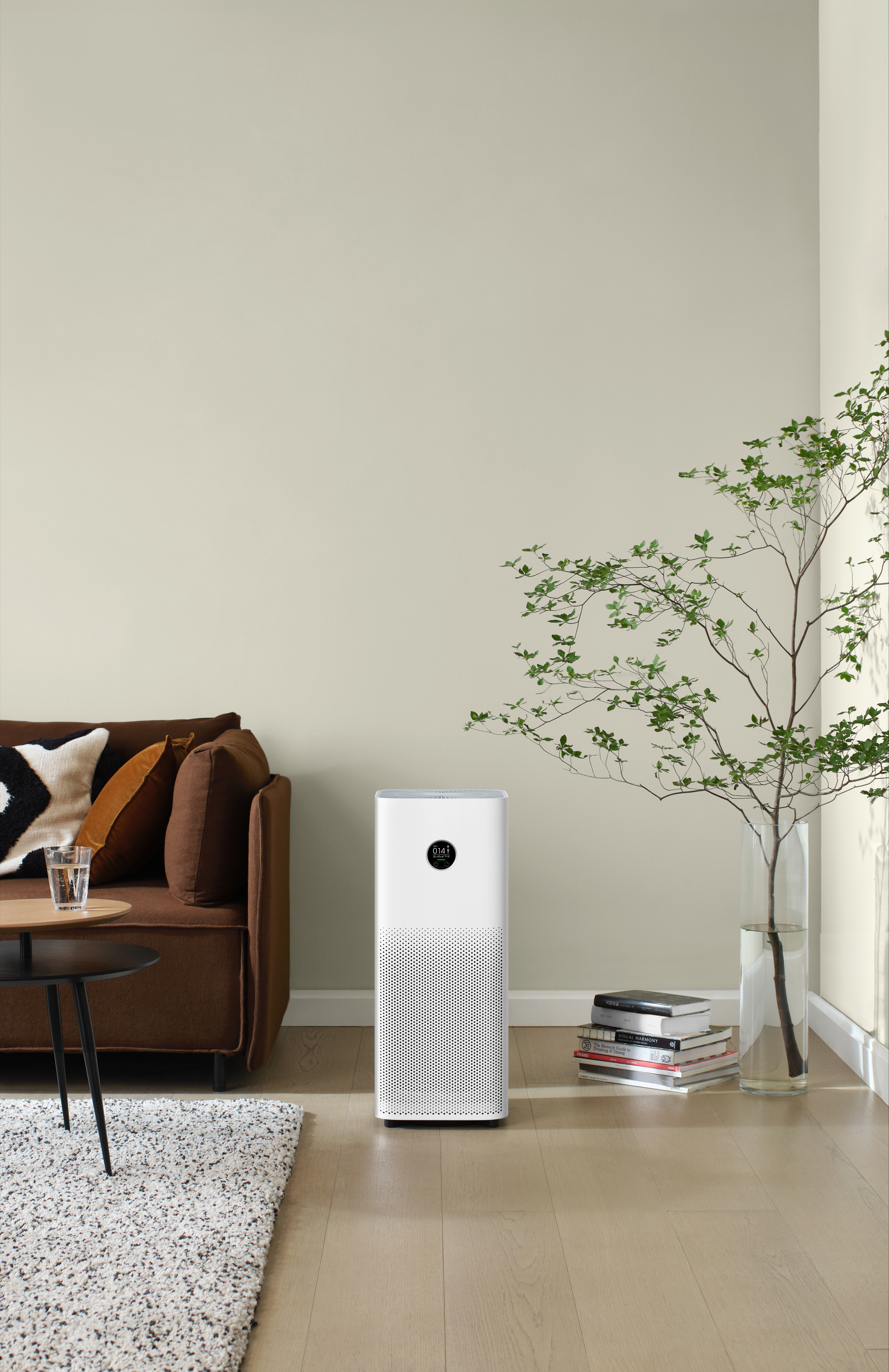 Kahverengi bir kanepenin bulunduğu modern bir oturma odasında beyaz bir hava temizleyici.