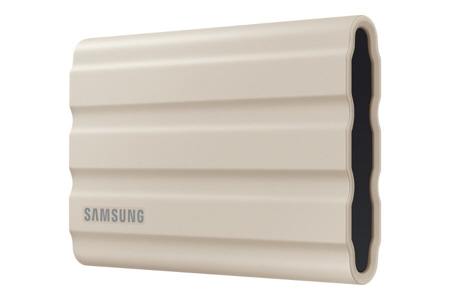 Zewnętrzny dysk twardy. Ma jasnobeżowy kolor i żebrowaną konstrukcję. Znajduje się na nim marka SAMSUNG.