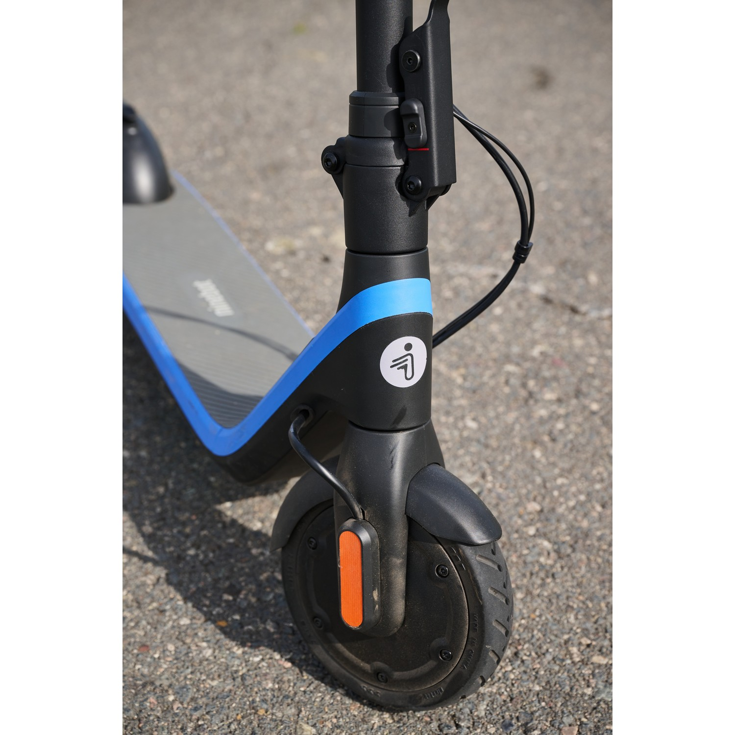 Close-up of an electric scooter's front wheel, showing the tire, fender, and a blue accent.
