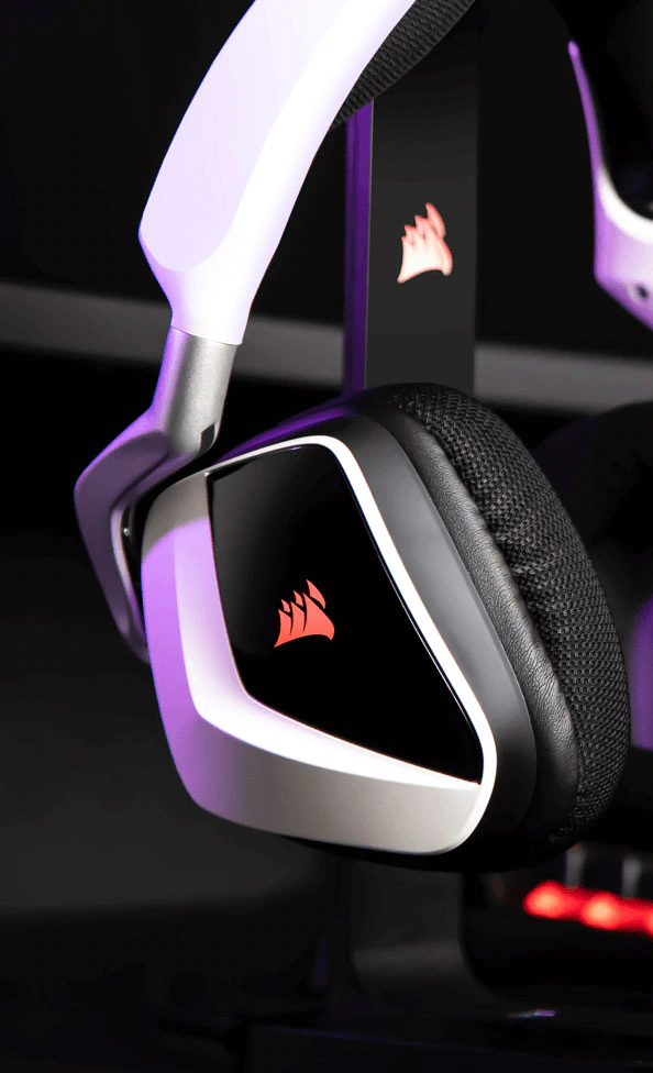 Fehér-fekete gamer headset Corsair logóval. A headset fekete állványon van.