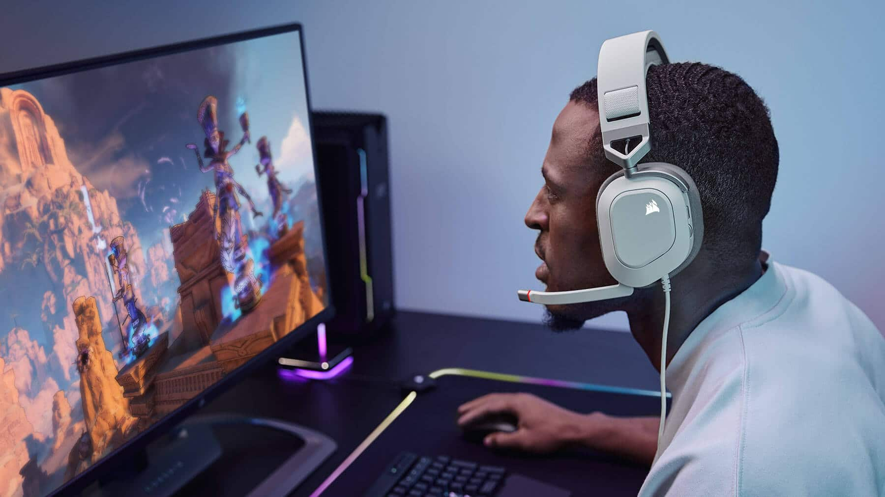 Férfi fejhallgatóval, videójátékot játszik egy monitoron, PC beállítással.