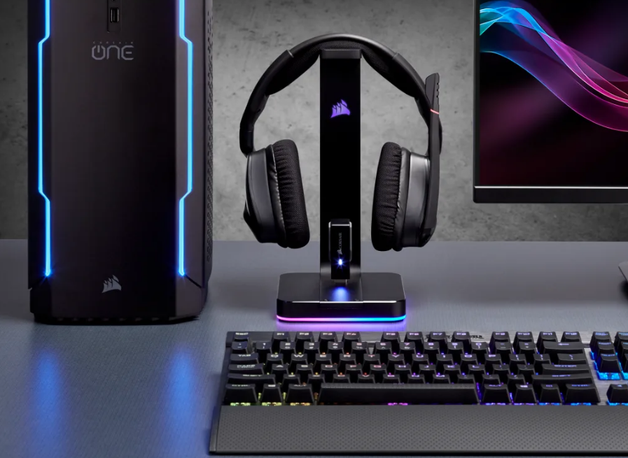 Fekete gaming setup, számítógéppel, fejhallgatóval, billentyűzettel és monitorral.