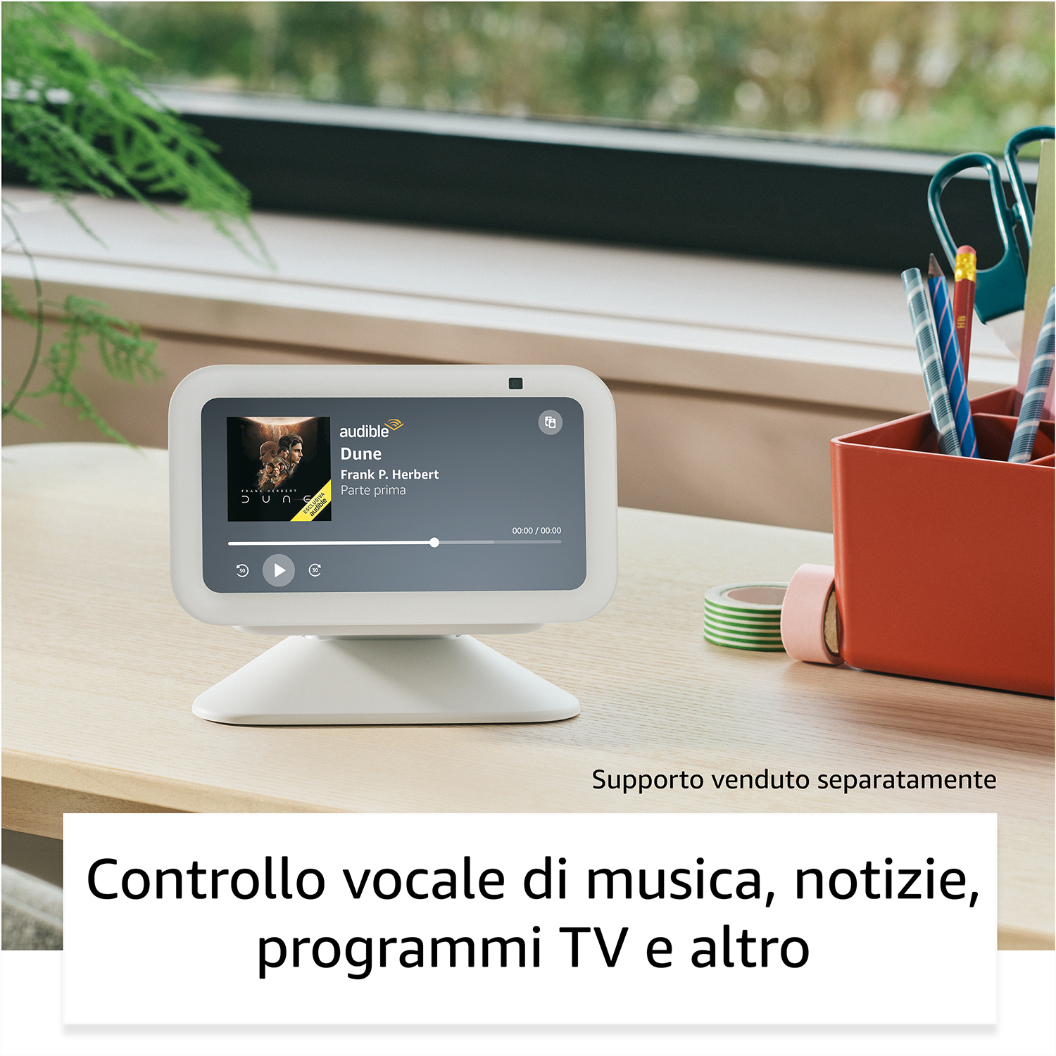 Un display smart bianco mostra i controlli musicali. Oggetti su una scrivania con una finestra sullo sfondo.