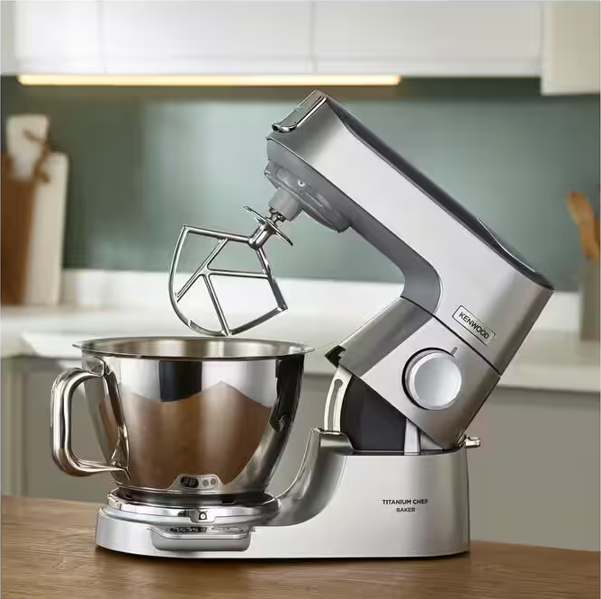 Un mixer da supporto argentato con una ciotola e un accessorio frusta.