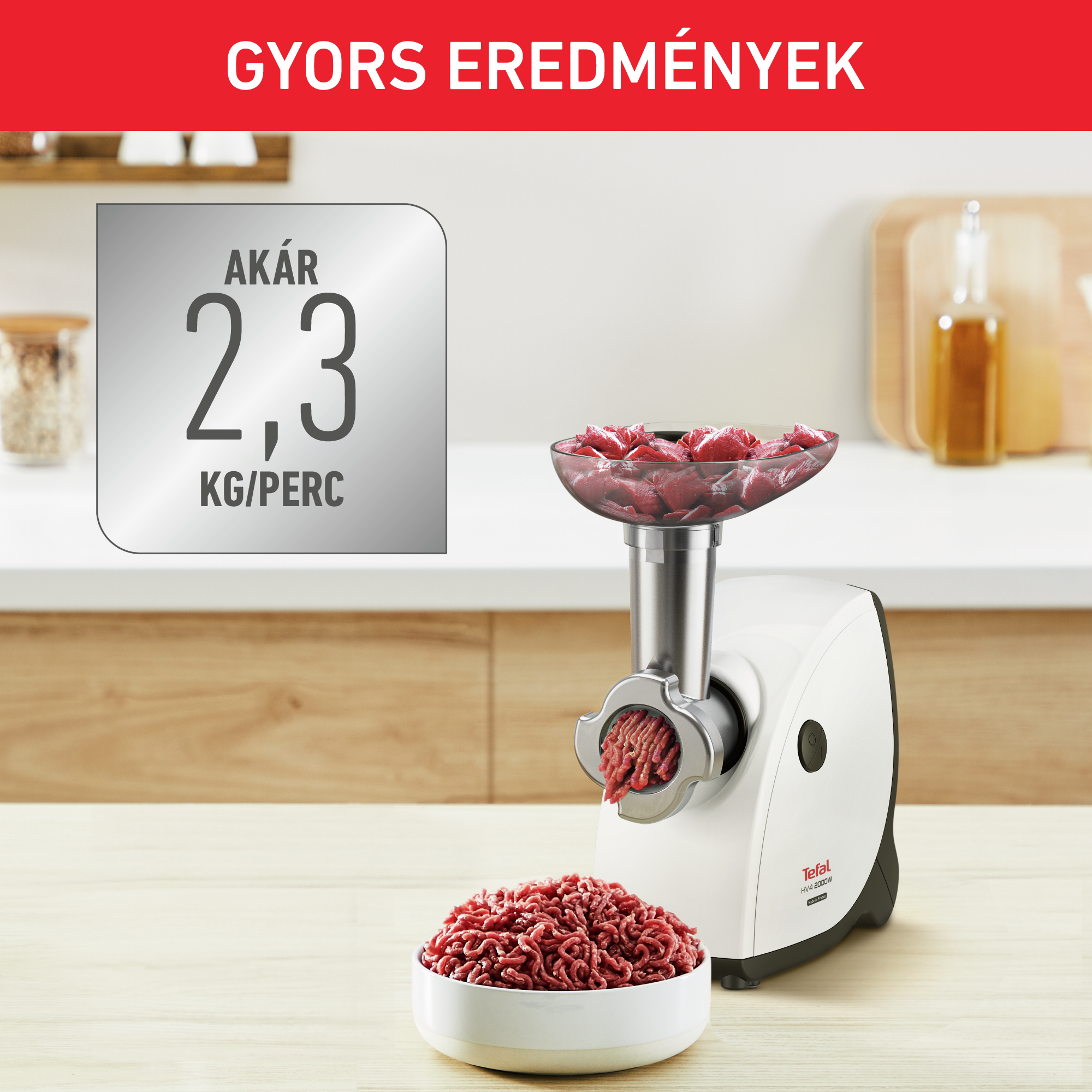 Egy fehér-fekete Tefal daráló, darált hússal és nyers hússal teli tálban.