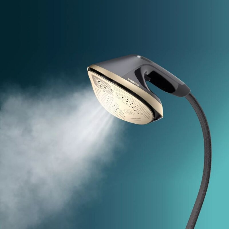 Żelazko z wydobywającą się parą, na tle niebiesko-zielonym.