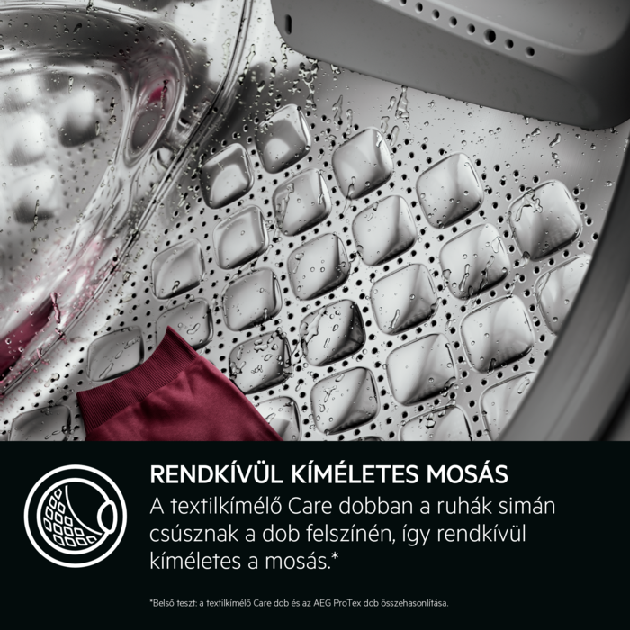 Mosógép dobja piros anyaggal. Mintás felület és vízcseppek láthatók.