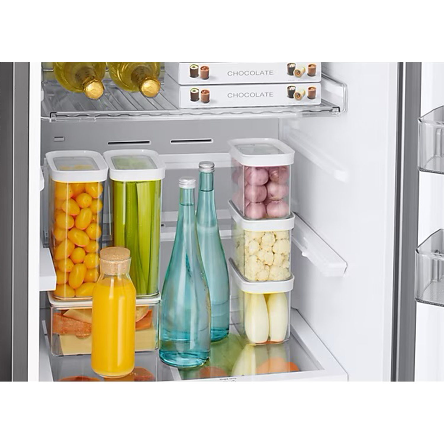 Intérieur d'un réfrigérateur avec des étagères remplies d'aliments, y compris des bouteilles et des contenants.