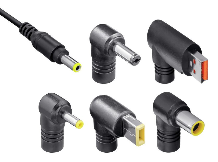 Różne czarne i szare zasilacze z żółtymi i srebrnymi końcówkami.