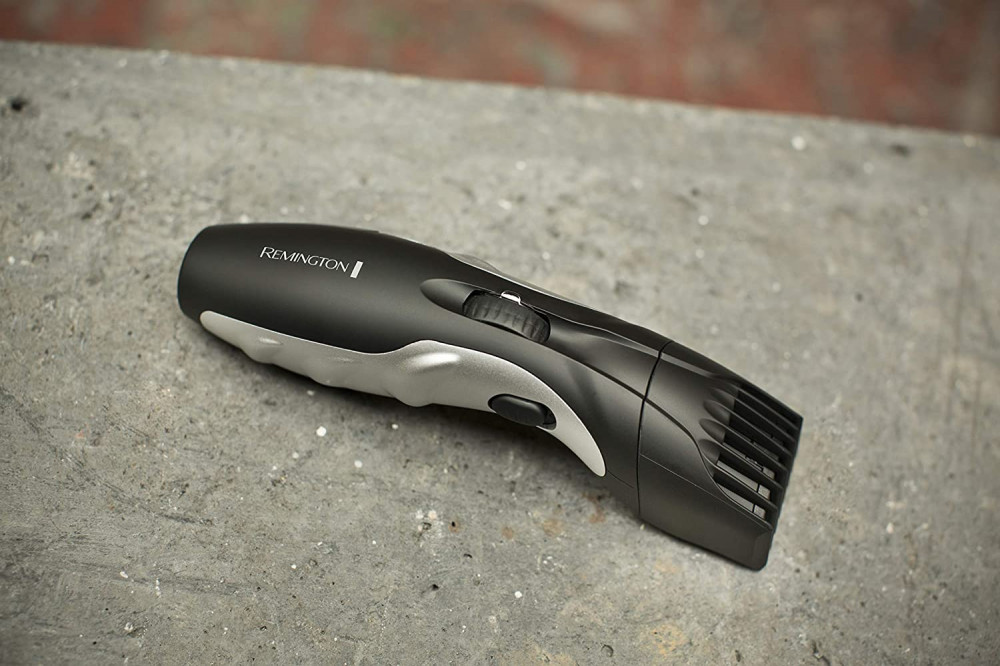 Fekete-szürke hajvágó szürke felületen. Remington logóval és tárcsával.