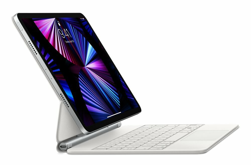 Srebrny iPad z etui na klawiaturę. Ekran wyświetla kolorowy design. Białe tło.