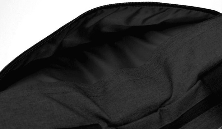 Zbliżenie wnętrza czarnej torby. Wnętrze to ciemny, miękki materiał.