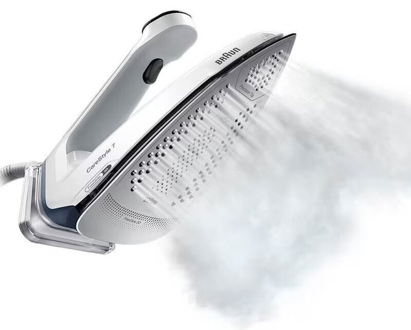 Białe żelazko z unoszącą się parą, ustawione pod kątem, aby pokazać spód, na białym tle.