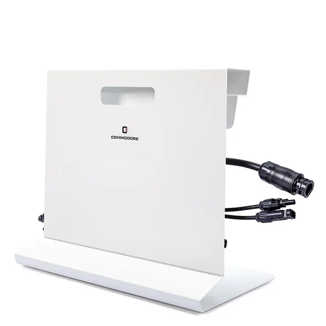 Ein weißes rechteckiges Commodore-Solarpanel mit schwarzen Kabeln und Steckern.
