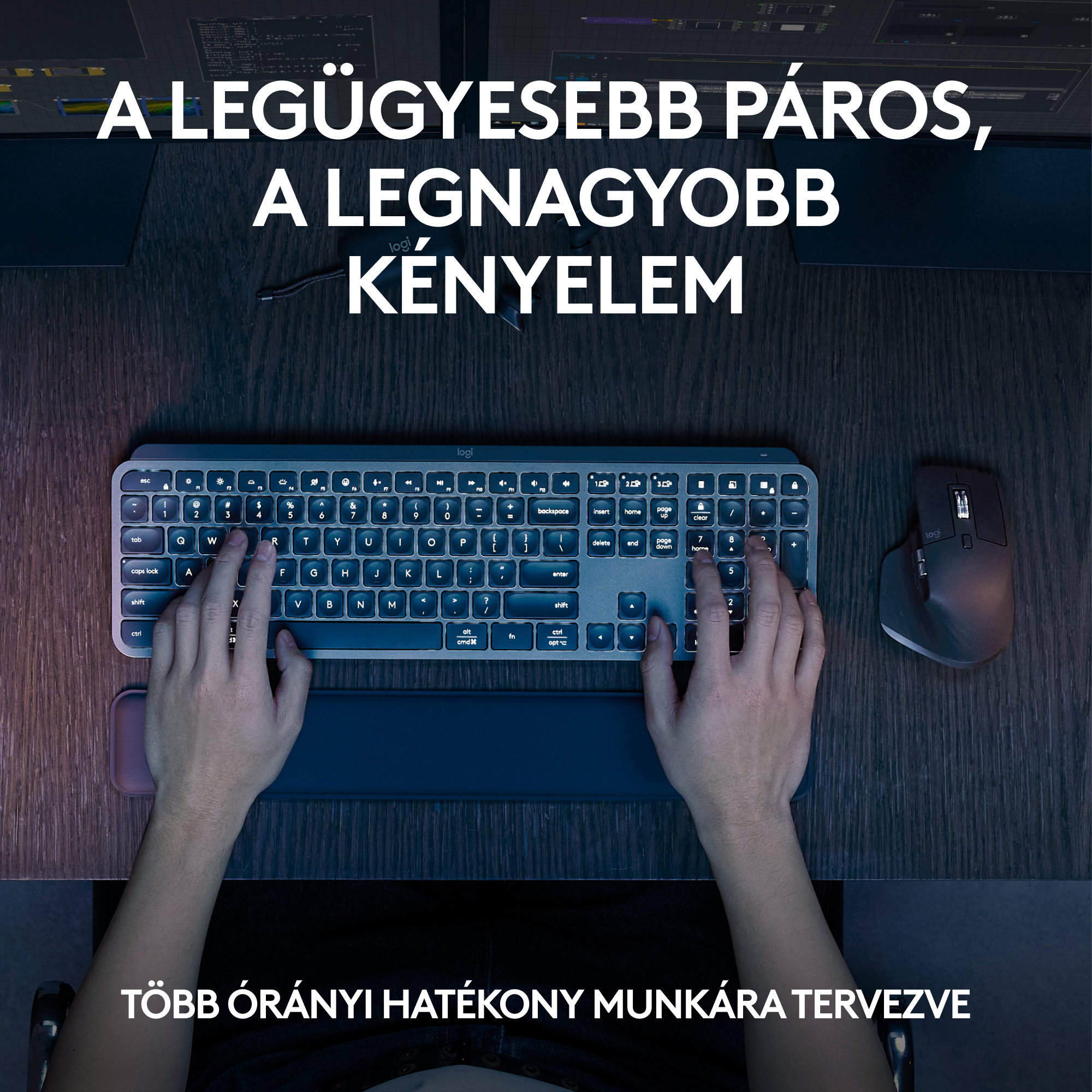 Személy billentyűzetet és egeret használ az asztalon. A billentyűzet kék fénnyel és csuklótámasszal rendelkezik.