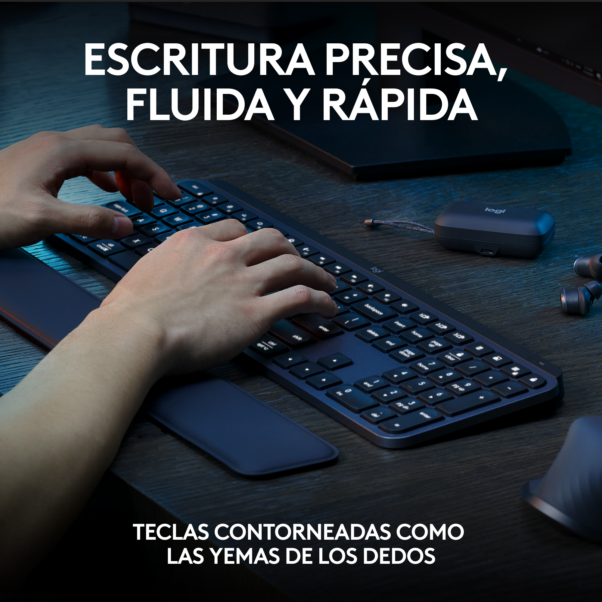Persona escribiendo en teclado oscuro. El teclado tiene reposamuñecas y el texto está en español.