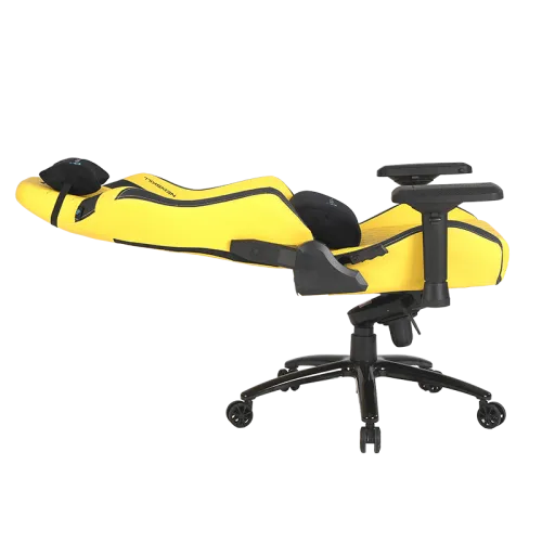 Una silla gamer amarilla con detalles negros sobre un fondo negro. La silla está en ángulo.