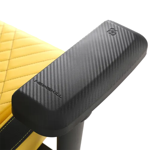 Primer plano de un reposabrazos negro con aspecto de fibra de carbono y la marca Newskill.