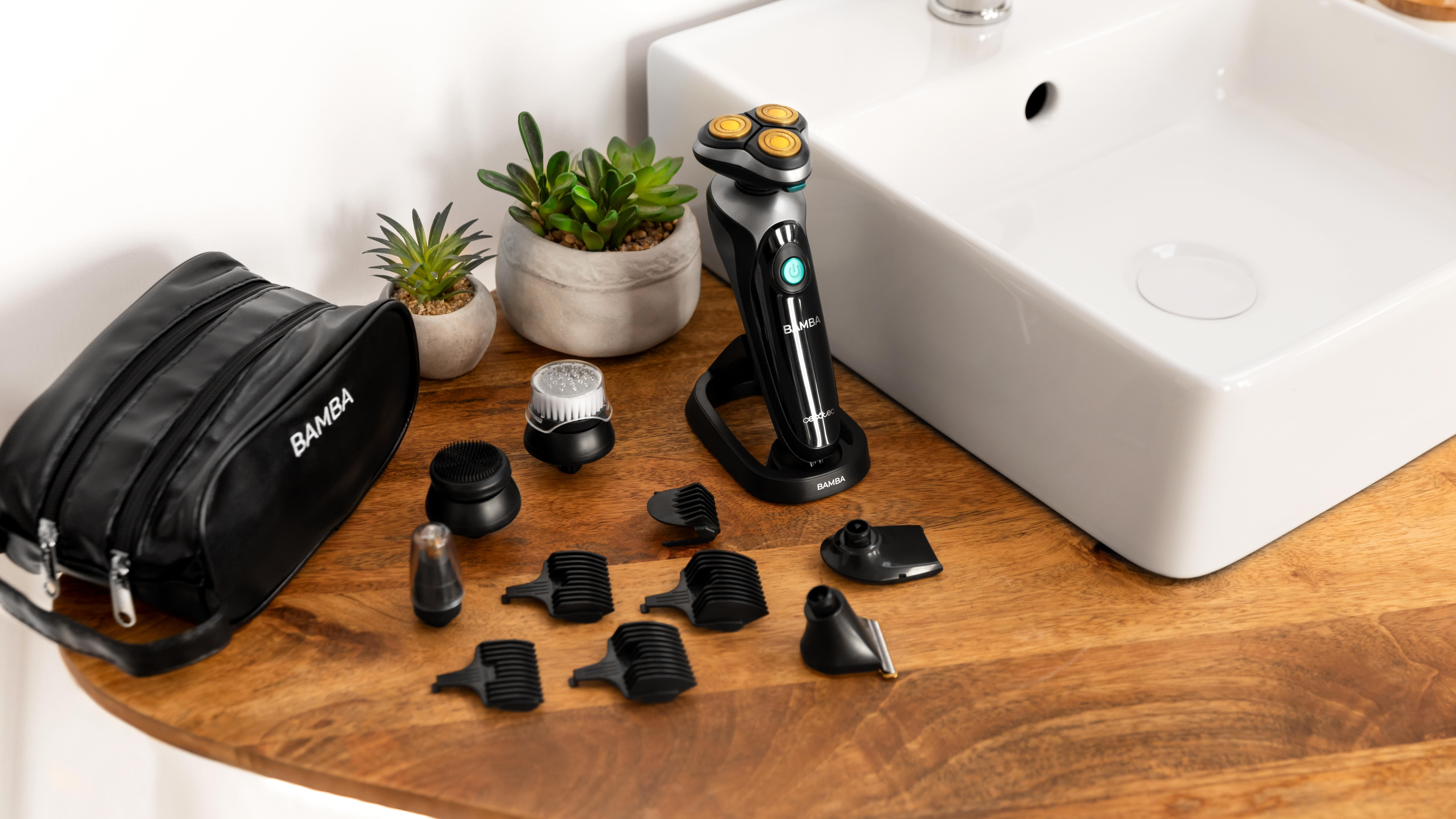 Una afeitadora eléctrica negra y plateada con varios accesorios y una bolsa de viaje sobre una superficie de madera.