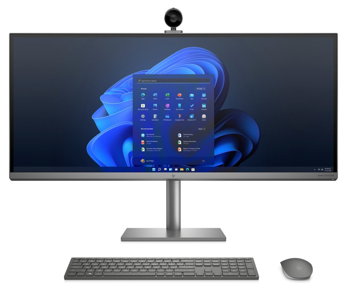 Srebrny monitor z kamerą, klawiaturą i myszą. Wyświetlany interfejs Windows 11.