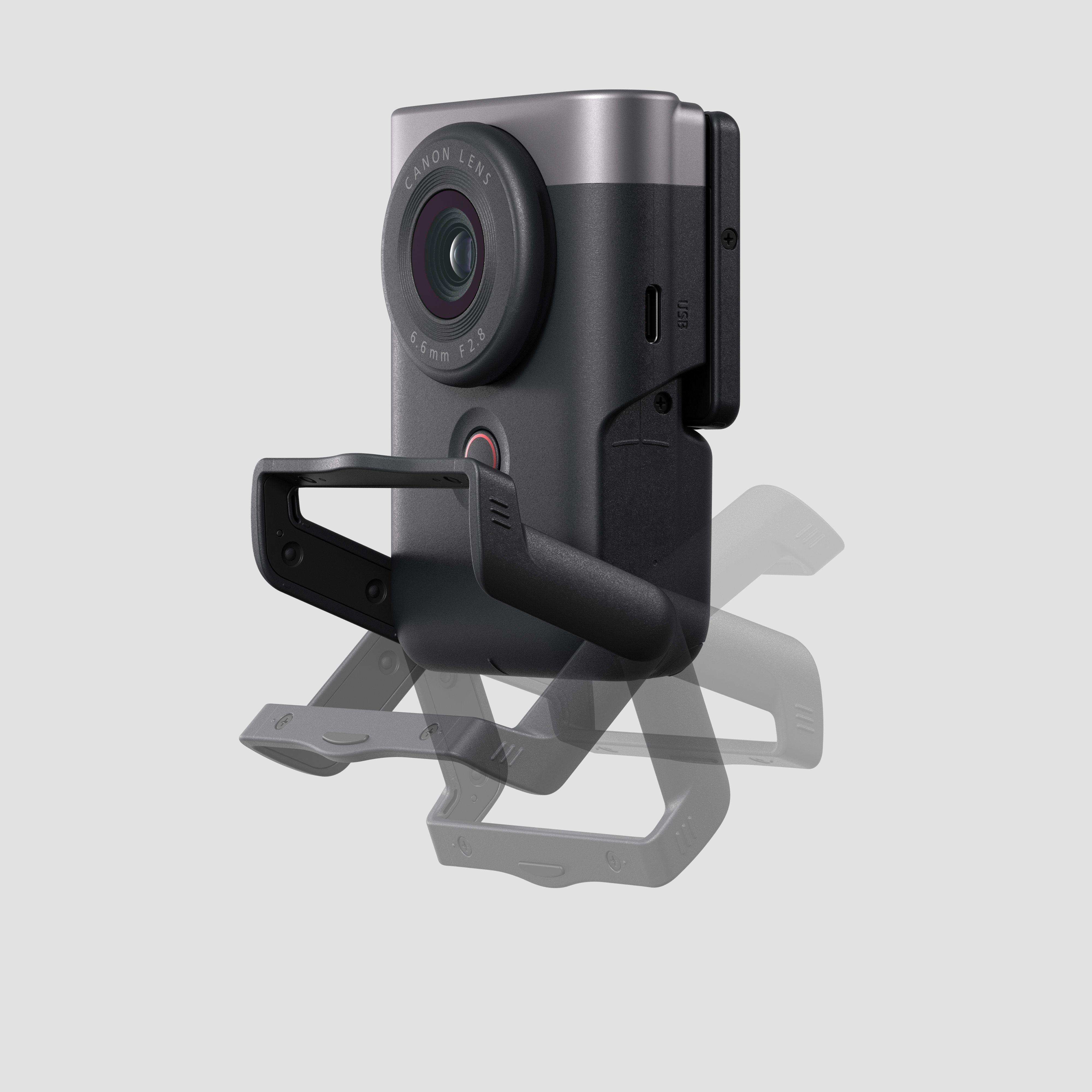 Caméra Canon noire, objectif et support de montage, sur fond gris, vue en angle.