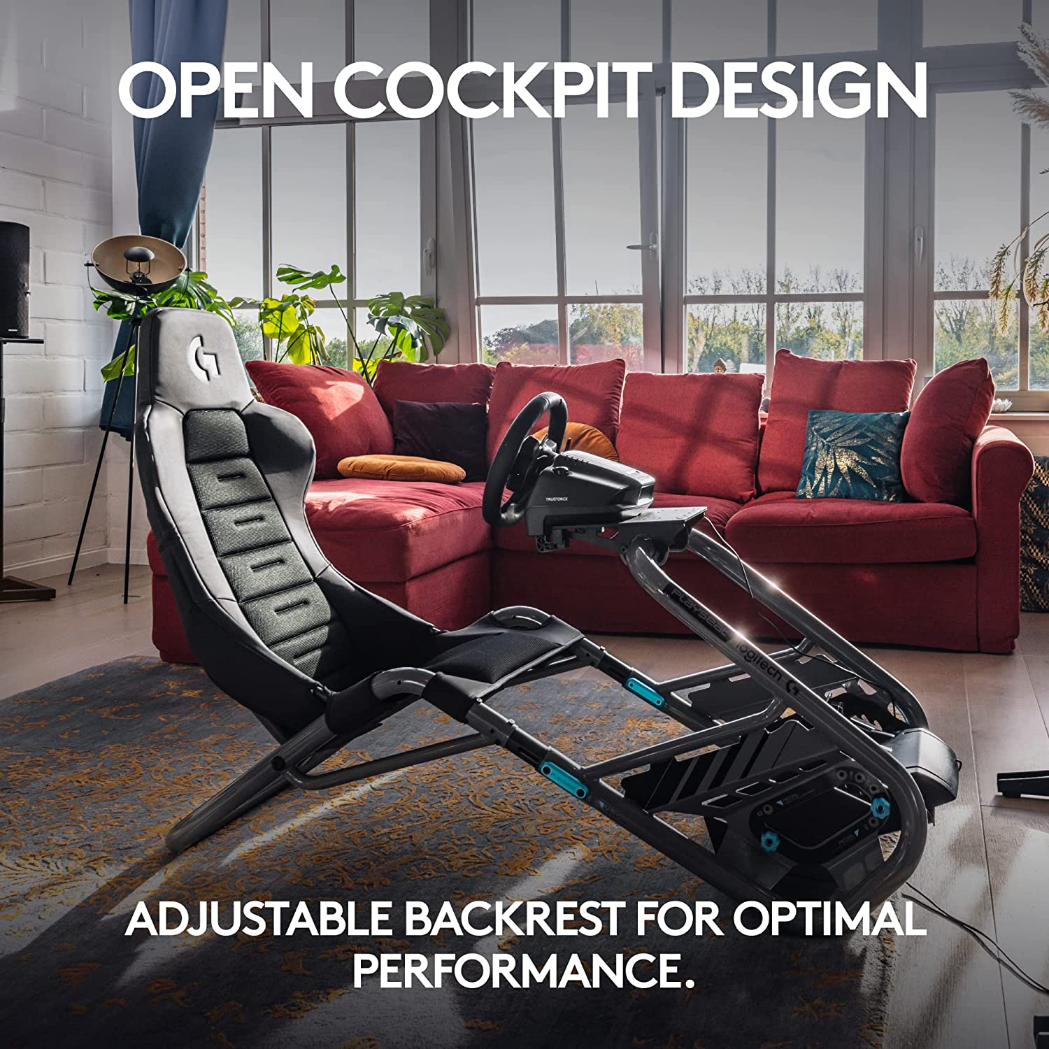 Rennsimulator-Cockpit mit Sitz, Lenkrad und rotem Sofa im Hintergrund.