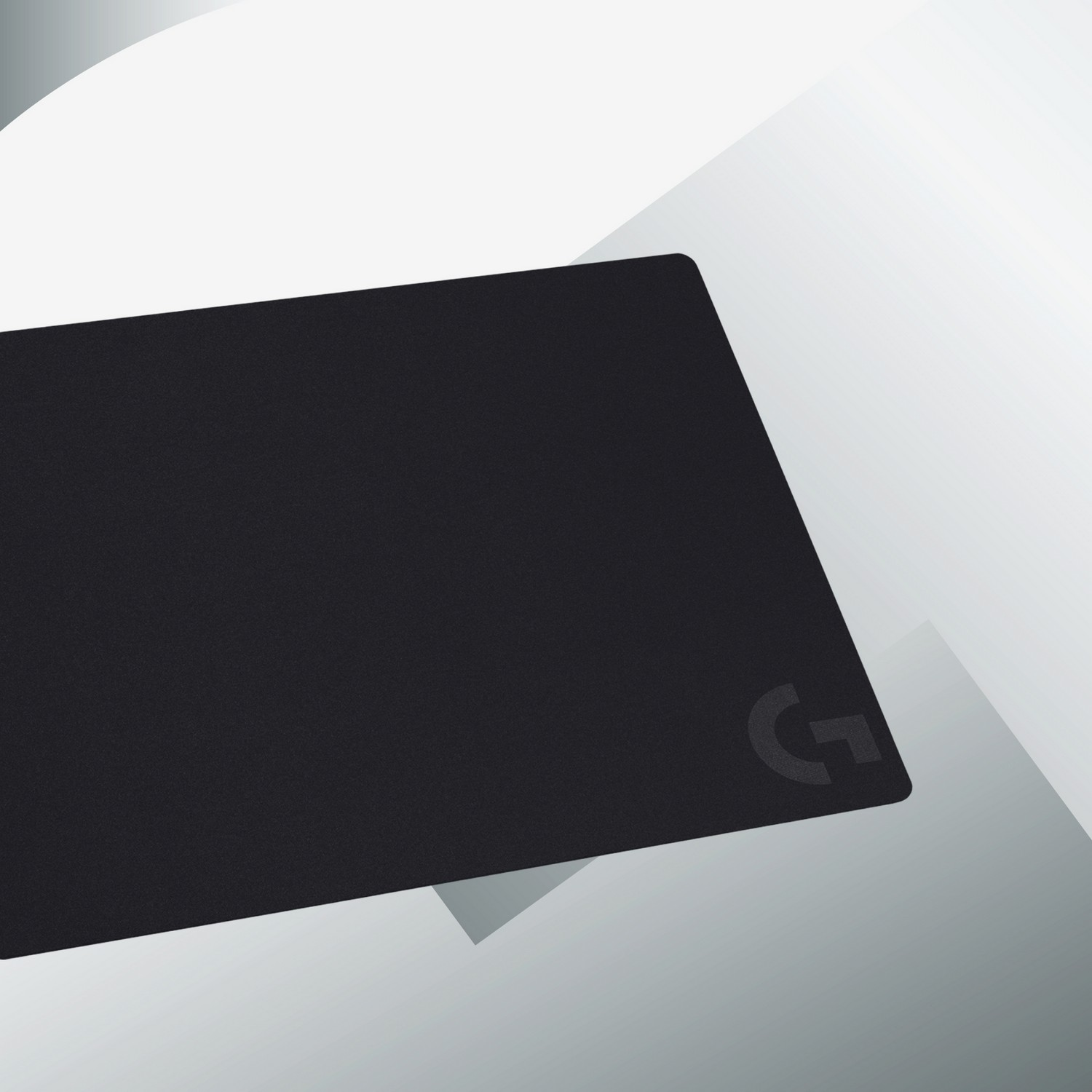 Tapis de souris Logitech rectangulaire noir avec logo 'G' sur un dégradé blanc et gris.