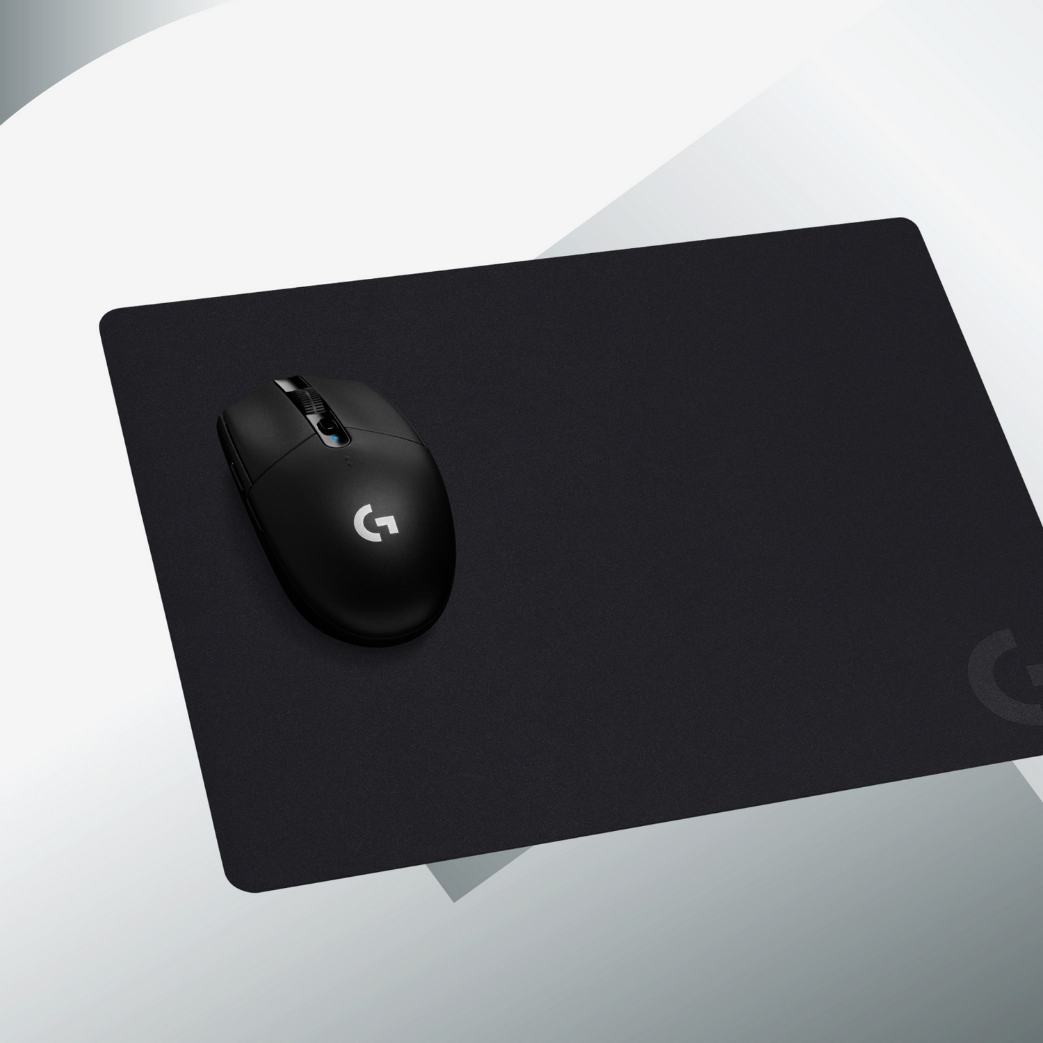 Une souris noire sur un tapis de souris noir, avec le logo Logitech.
