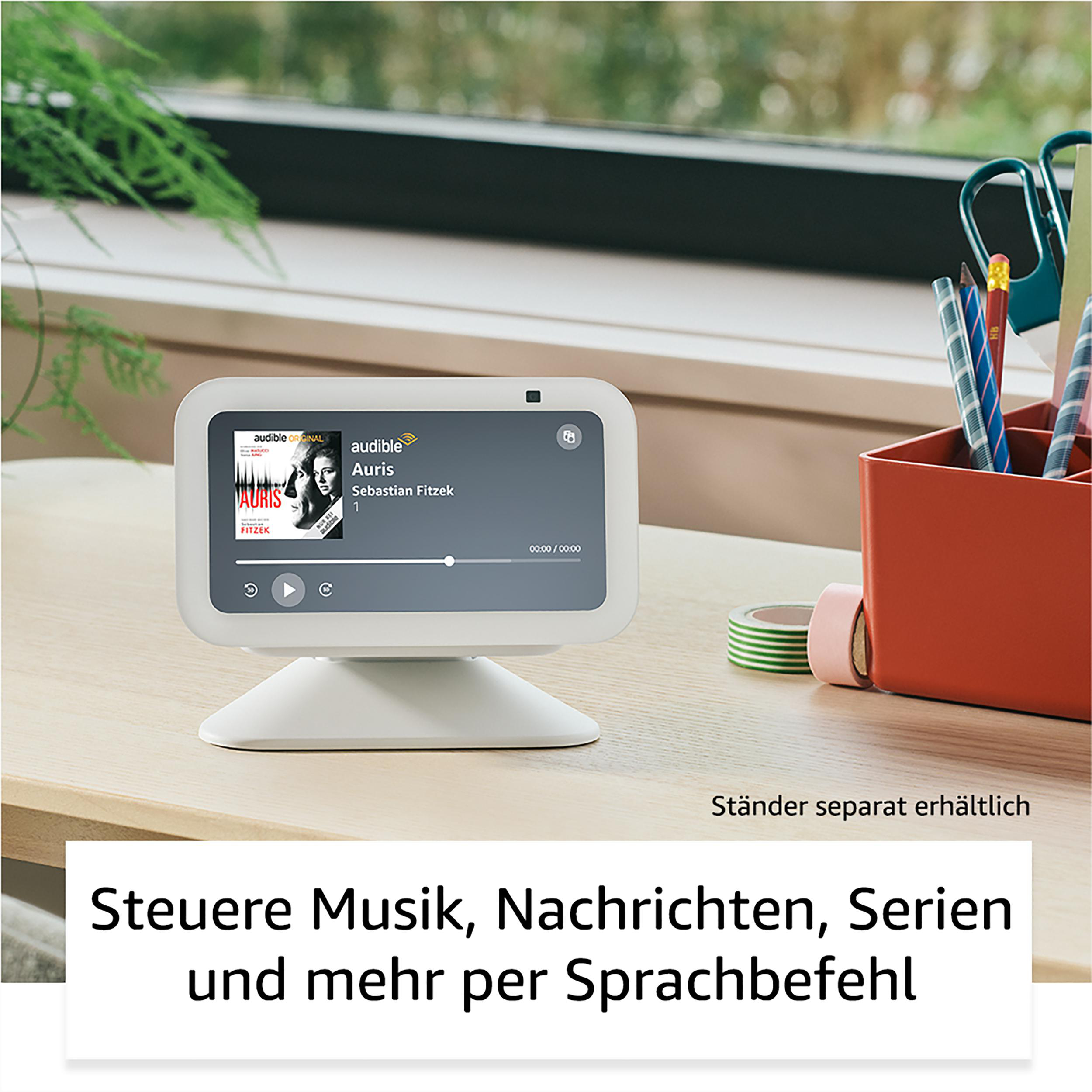 Ein kleiner, weißer Smart-Home-Bildschirm auf einem Holztisch. Der Bildschirm zeigt Musik.