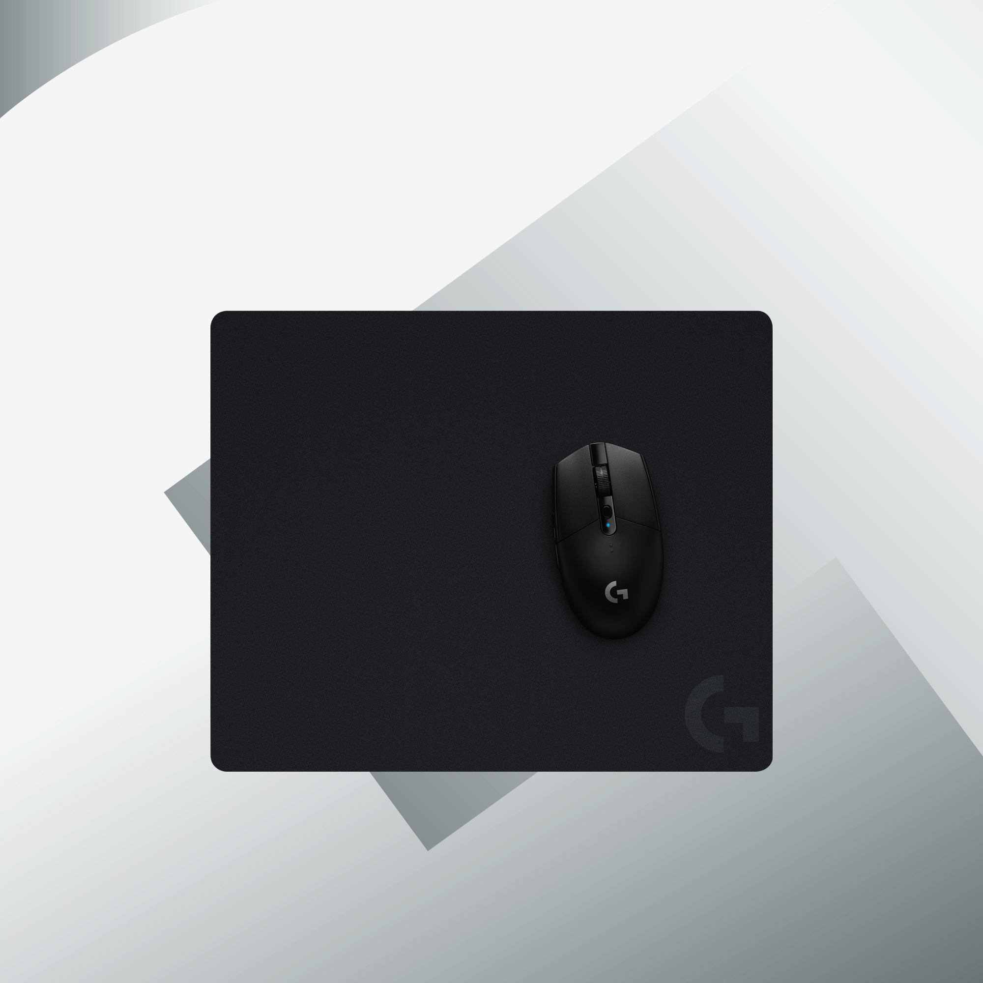Une souris noire sur un tapis de souris noir avec le logo Logitech dans le coin.