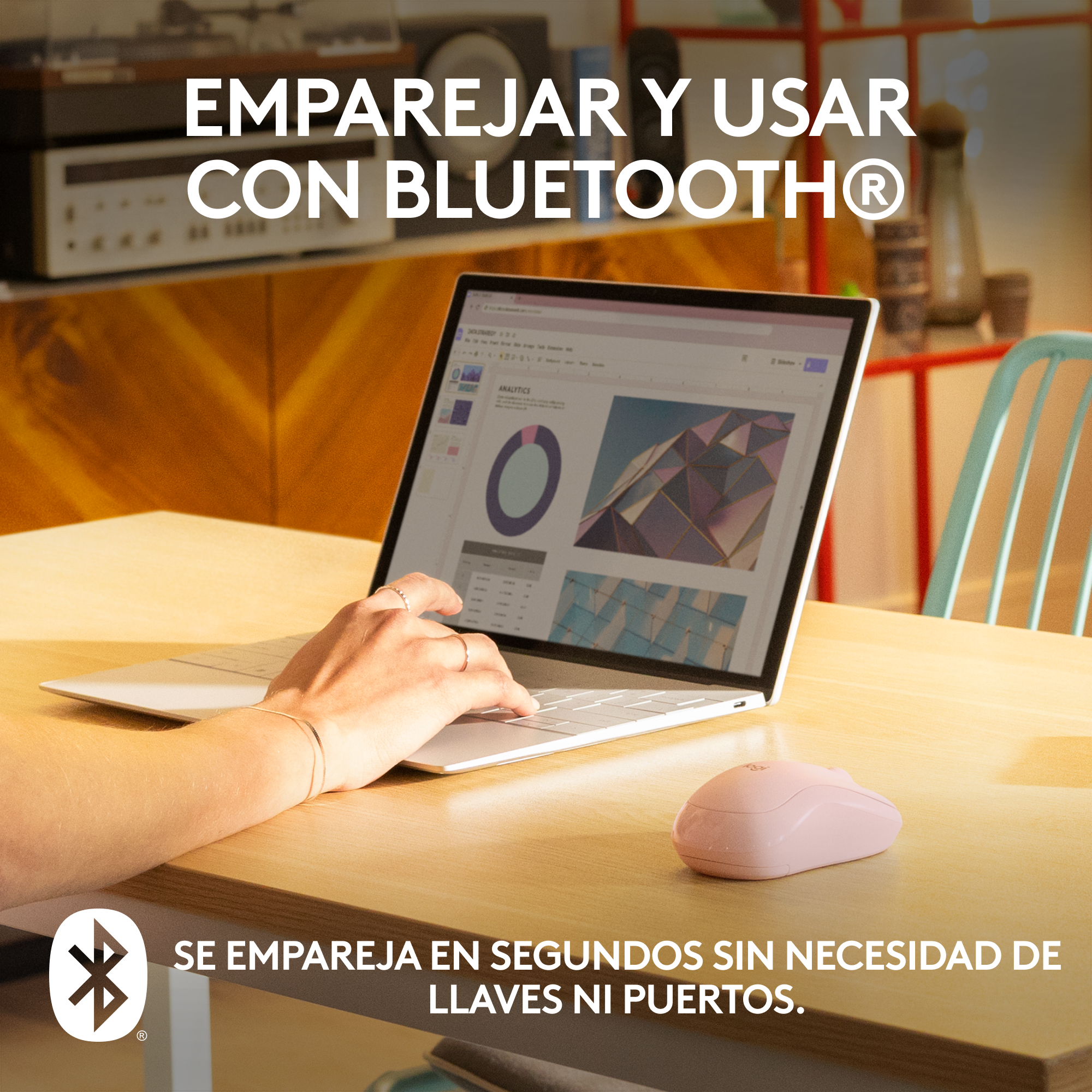 Mujer usando portátil con ratón rosa. Mesa de madera, interior. Logo Bluetooth.