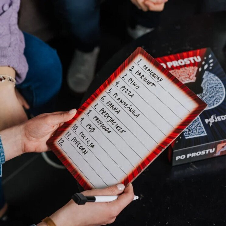 Gra planszowa z listą słów po polsku, trzymana przez dwie osoby.